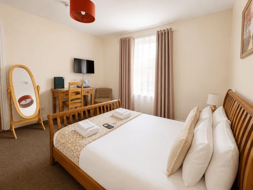Superior Double Room at The Cornerhouse Somerset with wooden bed, white linens, TV, desk, and mirror