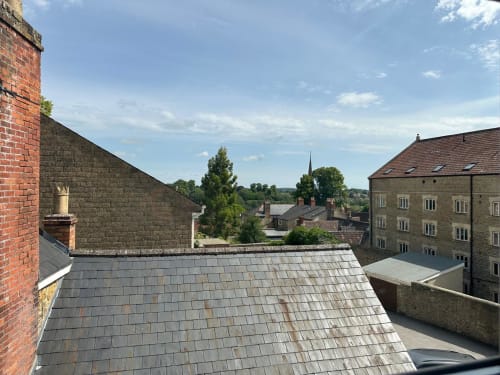 Rooftop view of Somerset village with stone buildings and countryside landscape from The Cornerhouse hotel