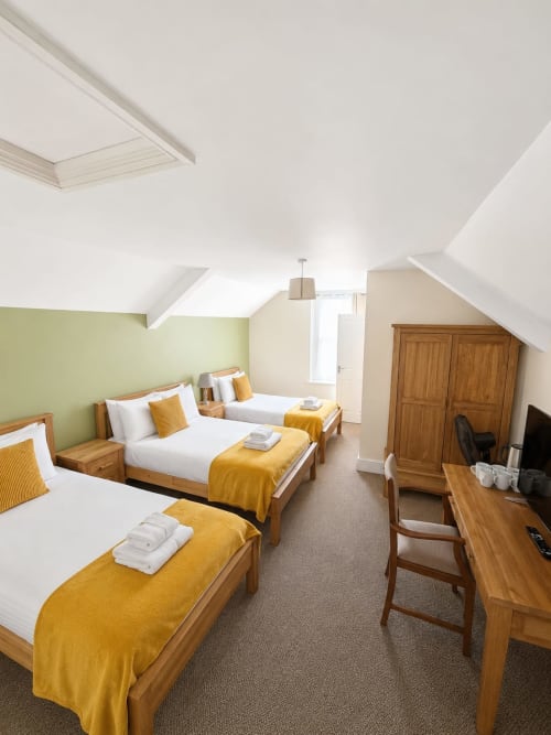 Bright Family Suite at The Cornerhouse Somerset with three beds, wooden furniture, yellow blankets, and skylights