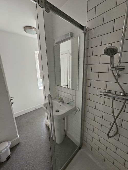 Modern bathroom at The Cornerhouse Somerset with walk-in shower, subway tile, sink, and rainfall showerhead