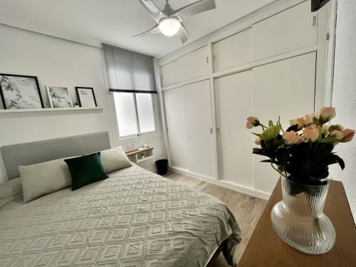 Habitación moderna en Pataconablue Rentals en Valencia con vistas a la ciudad, flores frescas y mobiliario contemporáneo