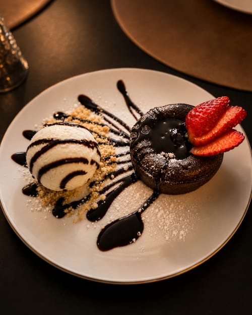 Sobremesa de chocolate gourmet com sorvete de baunilha, morangos frescos e calda de chocolate na Quinta dos Lobos Boutique
