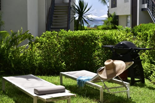 Garden view lounge area at O'Biches apartment in Trou-aux-Biches with sun loungers, straw hat, and lush greenery