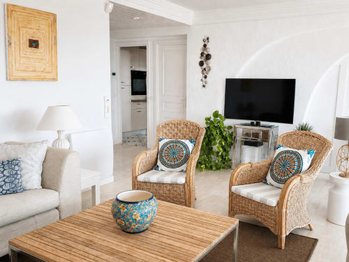 Bright living room at Le Saint Georges apartment in Cannes with wicker chairs, wooden table, sea view, and flat-screen TV