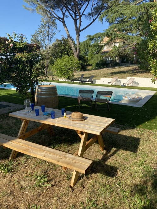 Table de pique-nique en bois près de la piscine du gîte Le Domaine les Olivoux à Pomport, France