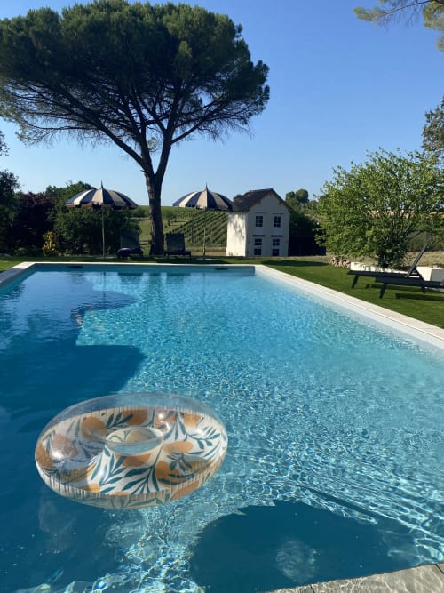 Piscine de luxe au Domaine les Olivoux à Pomport avec vue sur les vignobles et parasols