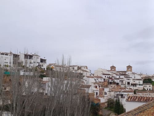 Villa encalada en Antequera con tejados de barro, cipreses y vistas a la montaña