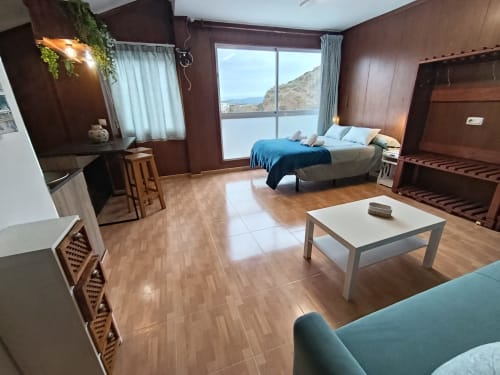 Espacioso dormitorio de la villa Luna en Antequera con vistas a las montañas, suelos de madera, cama doble, TV y mobiliario moderno