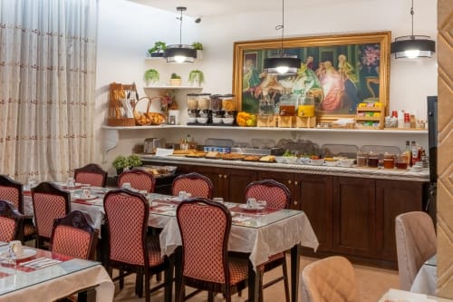 Hotel Royal Paris Ivry breakfast buffet with burgundy chairs, elegant dining area, and pastries display