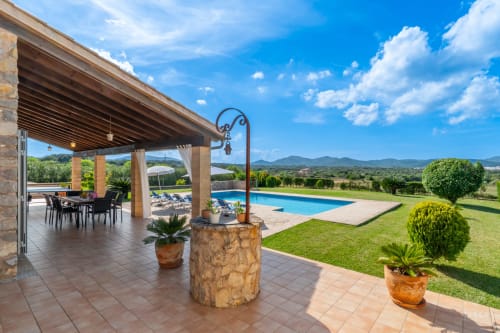Villa de lujo en Artá con terraza cubierta, comedor, piscina rectangular, jardines cuidados y vistas a la montaña