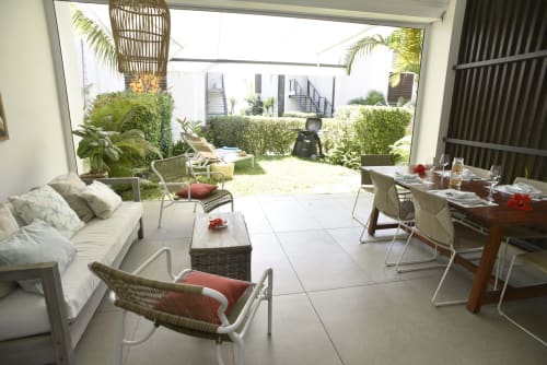 Premium holiday apartment in Trou-aux-Biches with open-plan living area, garden views, dining space, and furnished patio with