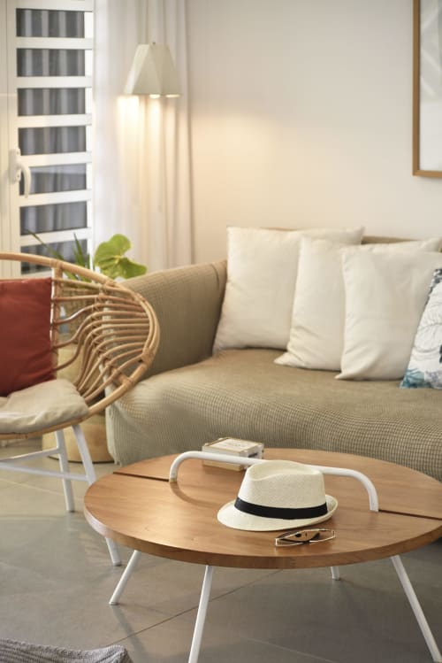 Modern living room with beige sofa, wooden coffee table, white hat and sunglasses at Unik Properties, Trou-aux-Biches
