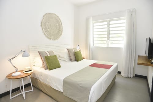 Bright modern bedroom at O'Biches Premium Apartment, Trou-aux-Biches with queen bed, green pillows, garden view through