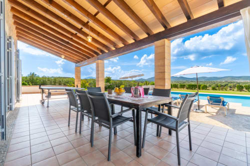 Terraza de lujo en Massa Properties en Artà con mesa de comedor, vistas a la piscina y paisaje montañoso
