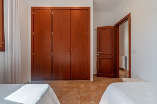Dormitorio espacioso en el hotel Massa Properties de Artà con armario de madera y camas gemelas