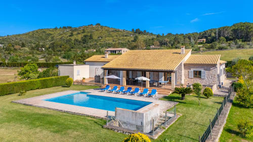 Villa de lujo en Artà con piscina, terraza y vistas al mar rodeada de jardines verdes y colinas