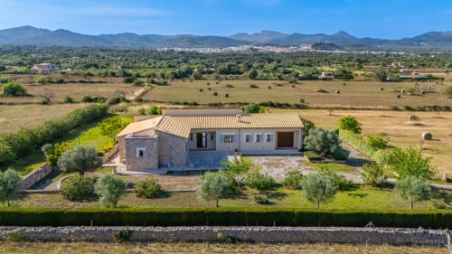 Villa de piedra moderna en Artà, Mallorca con vistas al campo, olivos y montañas al fondo