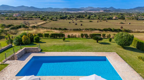 Piscina de lujo con vistas al paisaje rural cerca de Artà, España, rodeada de montañas y campos verdes