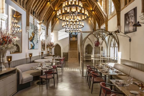 Elegant dining room at Three Little Pigs hotel in Blandford Forum with vaulted ceilings, chandeliers, and upholstered