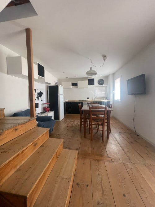 Appartamento open-plan a Casa Carmelo BnB a Schio con pavimenti in legno, cucina, zona pranzo e salotto con TV