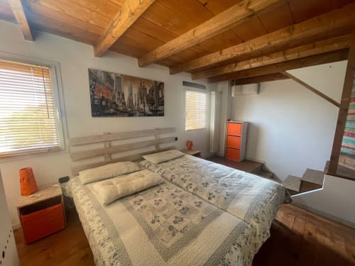 Ampia camera da letto presso Casa Carmelo BnB a Schio con travi a vista in legno, letto matrimoniale e comfort moderni