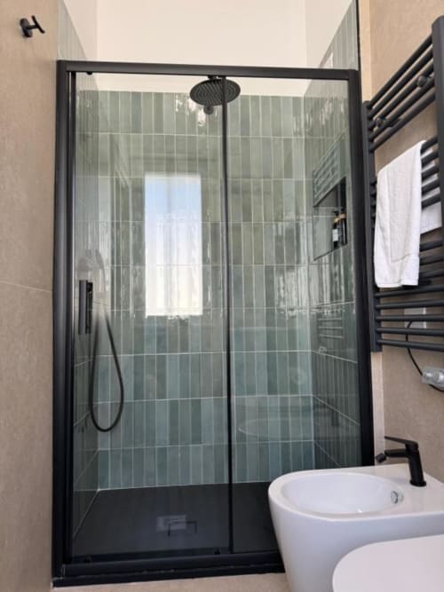 Bagno moderno con box doccia in vetro e cornici nere, piastrelle verde salvia e lavabo bianco a Maison ì Room a Reggio