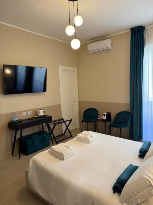 Deluxe Triple Room presso Maison ì a Reggio Calabria con letto, scrivania, TV, lampade a sospensione moderne e balcone con vista mare.
