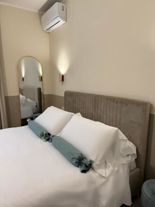 Camera da letto lussuosa a Maison ì Room a Reggio Calabria con letto, specchio e climatizzatore a parete
