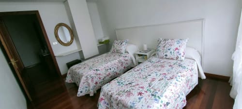 Camera doppia dell'Apartamento San Antonio a Monforte de Lemos con biancheria a fiori e testiere bianche