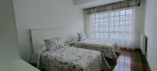 Camera doppia con biancheria floreale e ampia finestra in Apartamento San Antonio, Monforte de Lemos