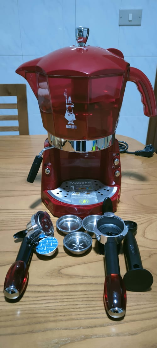 Caffettiera espresso Bialetti Mokona rossa con accessori esposti su tavolo in legno nell'appartamento Monforte