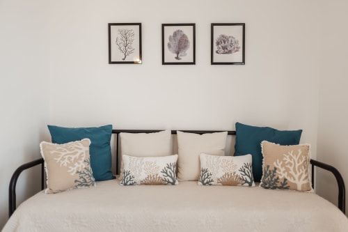 DORY room bed with coral-themed pillows and wall art at Casanova B&B in Cefalù
