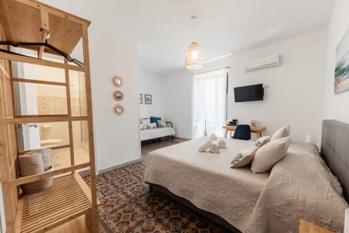 Chambre spacieuse au Casanova B&B à Cefalù avec lit double, canapé-lit, TV écran plat et vue sur la ville