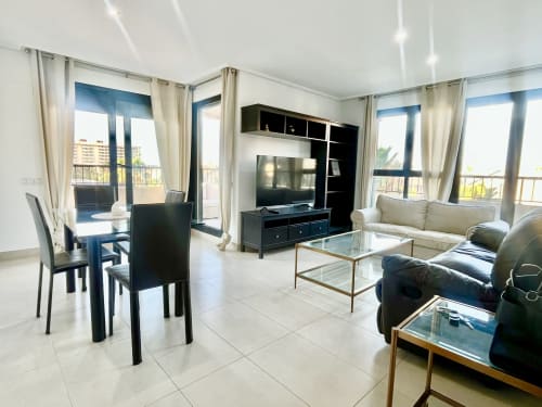 Moderno salón con comedor, televisión y vistas al mar desde el balcón, Valencia