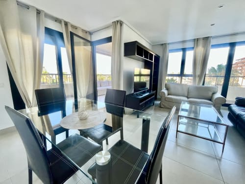 Moderno salón de apartamento frente al mar en Valencia con comedor, vistas al mar y balcón amueblado con vista a la estación costera