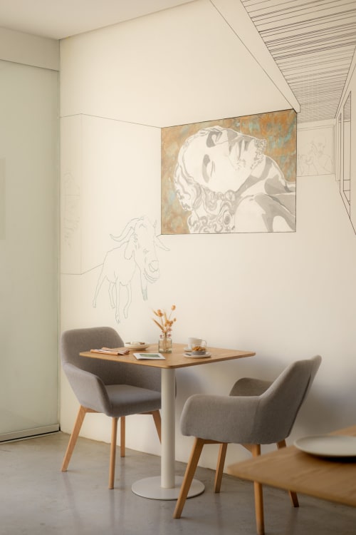 Modern meeting nook at Hotel Fragile Menorca with minimalist décor, small wooden table, gray chairs, and artistic wall