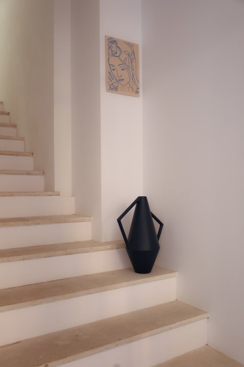 Modern staircase at Hotel Fragile in Ciutadella de Menorca with black sculptural vase and minimalist line art on wall