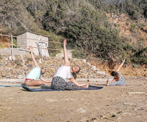 Ospiti che praticano yoga all'aperto presso Casa Pineta a Marina di Campo, Italia