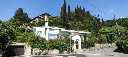 Hotel Prince Garda in Salò, Italien - modernes weißes Gebäude mit grünem Efeu und Zypressen am Berghang