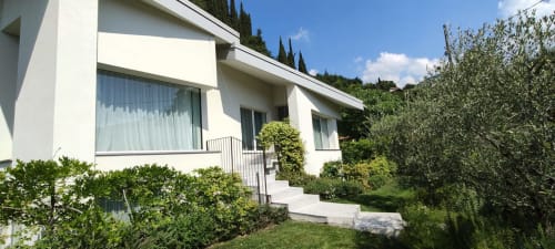 Moderne weiße Villa des Hotels Prince Garda in Salò mit Terrasse, großen Fenstern und üppigen mediterranen Gärten