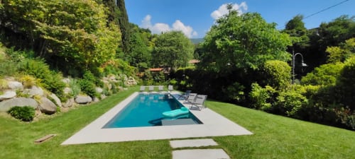 Luxus-Pool Prince Garda mit Liegestühlen, umgeben von grünen Rasenflächen und Bäumen in Salò, Italien