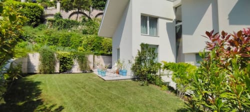 Modernes weißes Haus mit grünem Rasen, Terrassenmöbeln und efeubedeckten Wänden im Hotel Prince Garda in Salò