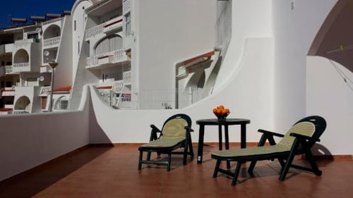 Área de estar na varanda do Albufeira Inn com espreguiçadeiras com vista para a arquitetura branca em Albufeira, Portugal