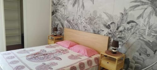 Quarto aconchegante na Albufeira Inn com cama de madeira, almofadas rosa, roupa de cama estampada, papel de parede tropical e móveis de madeira