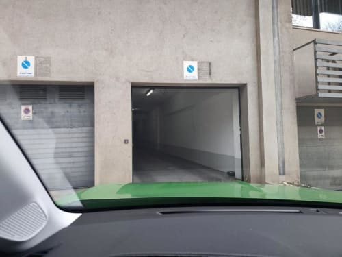 Capó de carro verde na entrada do edifício Albufeira Inn com portas de garagem e localização no centro da cidade