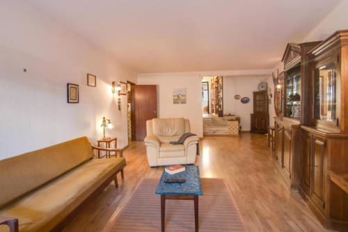 Sala de estar espaçosa no apartamento Albufeira Inn com móveis em madeira, sofá creme e vista para o centro da cidade