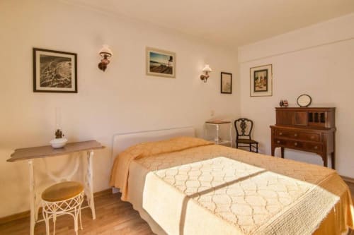 Quarto em apartamento de 2 assoalhos no Albufeira Inn com cama, móveis em madeira e quadros nas paredes
