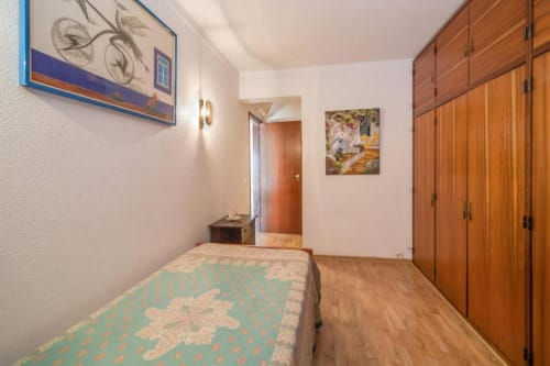 Quarto aconchegante na Albufeira Inn com cama de solteiro, guarda-roupa de madeira e acesso a comodidades modernas no centro da cidade