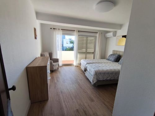 Quarto luminoso de T1 em Albufeira com cama de casal, varanda, assoalho em madeira e comodidades modernas perto de Praia dos