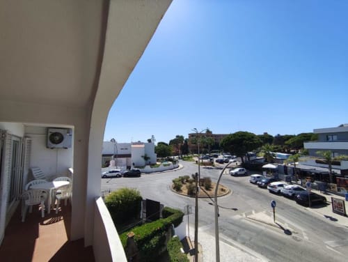 Vista da varanda do Albufeira Inn com vista para estacionamento, palmeiras e zona residencial perto da Praia dos Aveiros